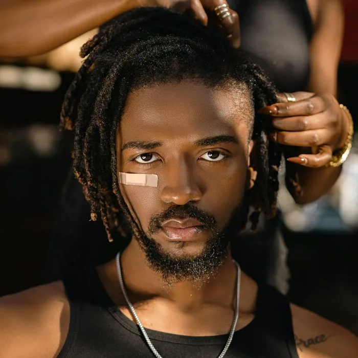 Illustrative photo of a stylist maintaining a client's locs